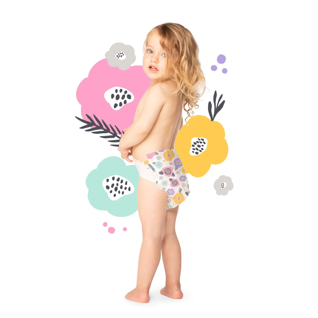 Child in floral diaper, colorful flower background.