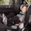 A child in the back of a car seat.