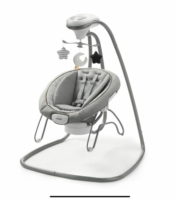 A baby swing with a remote control attached to it.