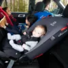 A baby in the back of a car seat.