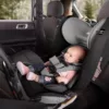 A baby in the back of a car seat.